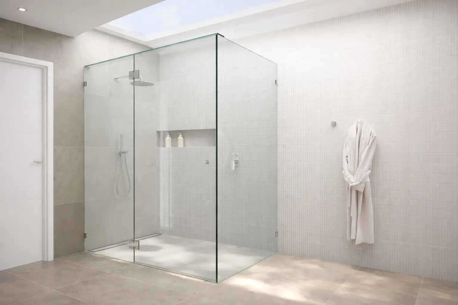 Frameless glass shower enclosure with chrome hardware and skylight in modern bathroom