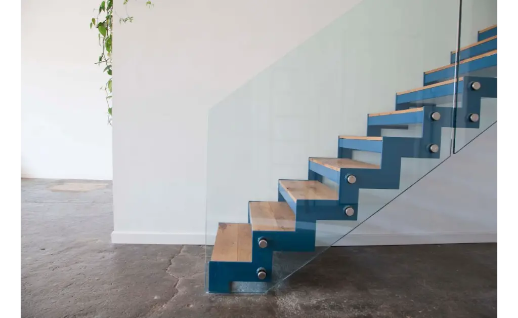 Glass staircase railing with standoff fittings and frameless glass panel