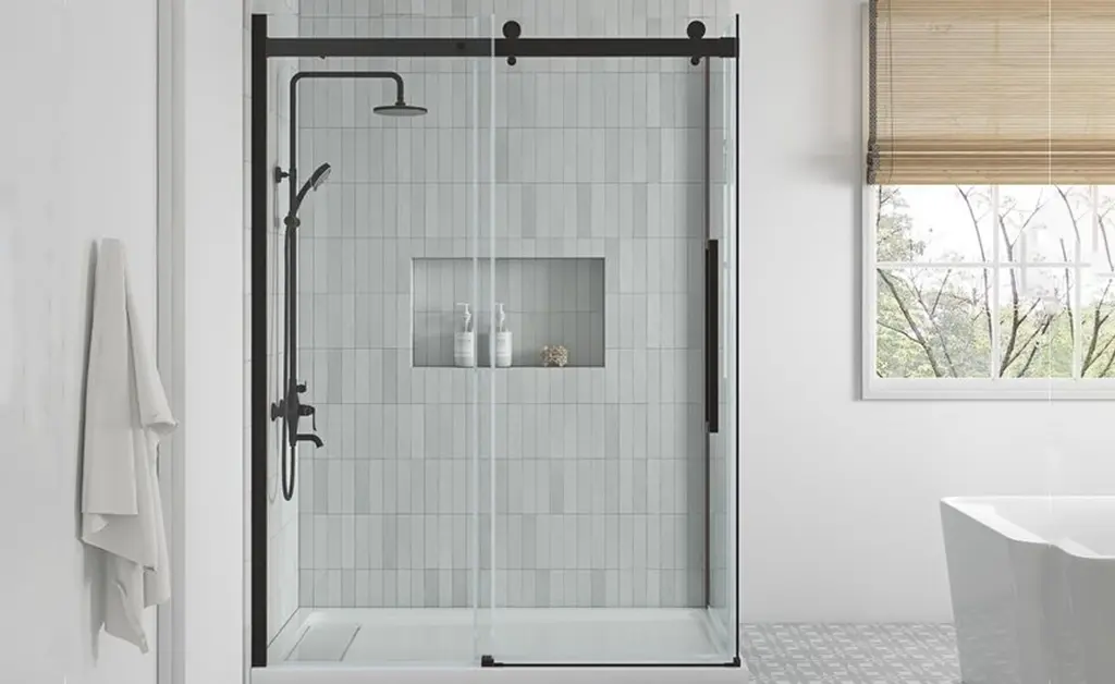 Matte black sliding glass shower door with barn door track hardware in modern bathroom