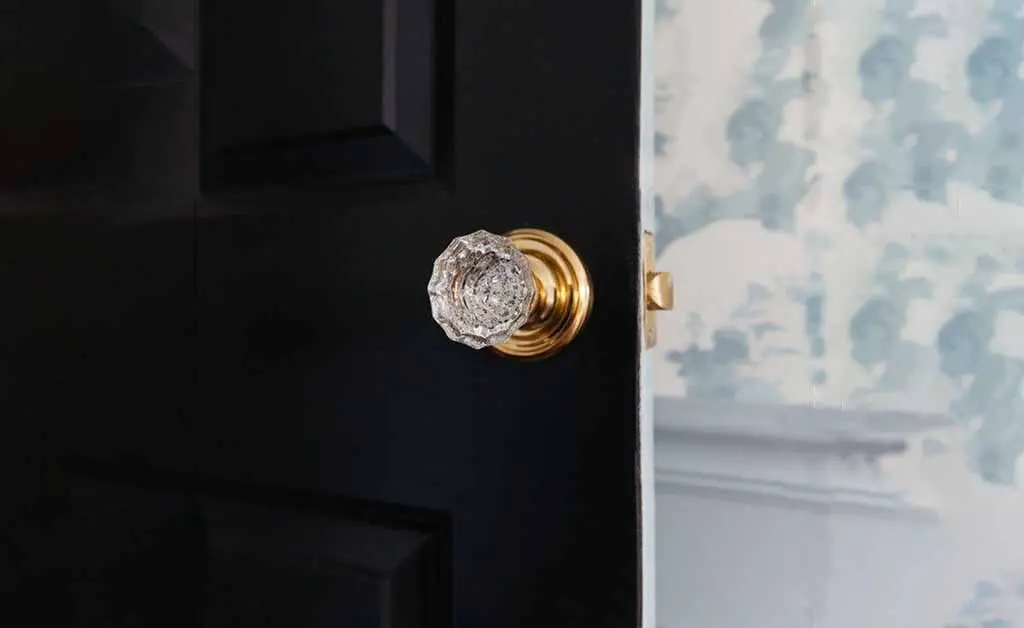 Vintage crystal glass door knob with brass fitting on classic black door